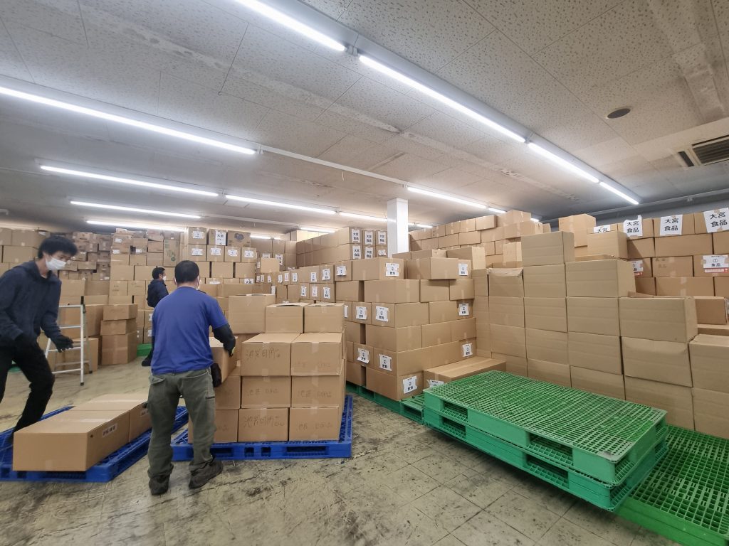 急な入荷決定に対応できるよう天井高くまで積み上げ省スペースに